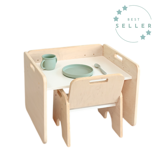 Montessori weaning table and chair set made from plywood with a white tabletop. Perfectly sized for toddlers to eat, play, or work independently. Includes a sage green toddler plate, cup, and spoon to support self-feeding and autonomy, from Sapiens Child made in Canada.