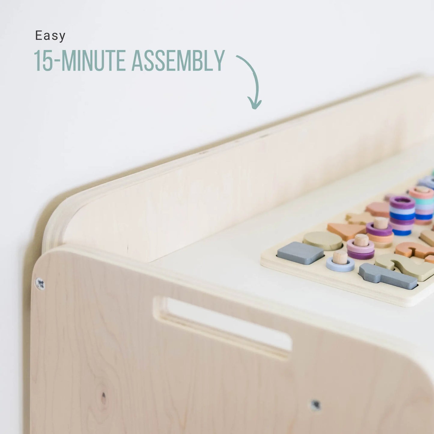 Closeup of a Premium Montessori shelf for toddlers, made in Canada from plywood with rounded corners. Features three accessible levels for toys and learning materials, including green storage bins on the bottom shelf, designed to encourage independence and organization in young children.