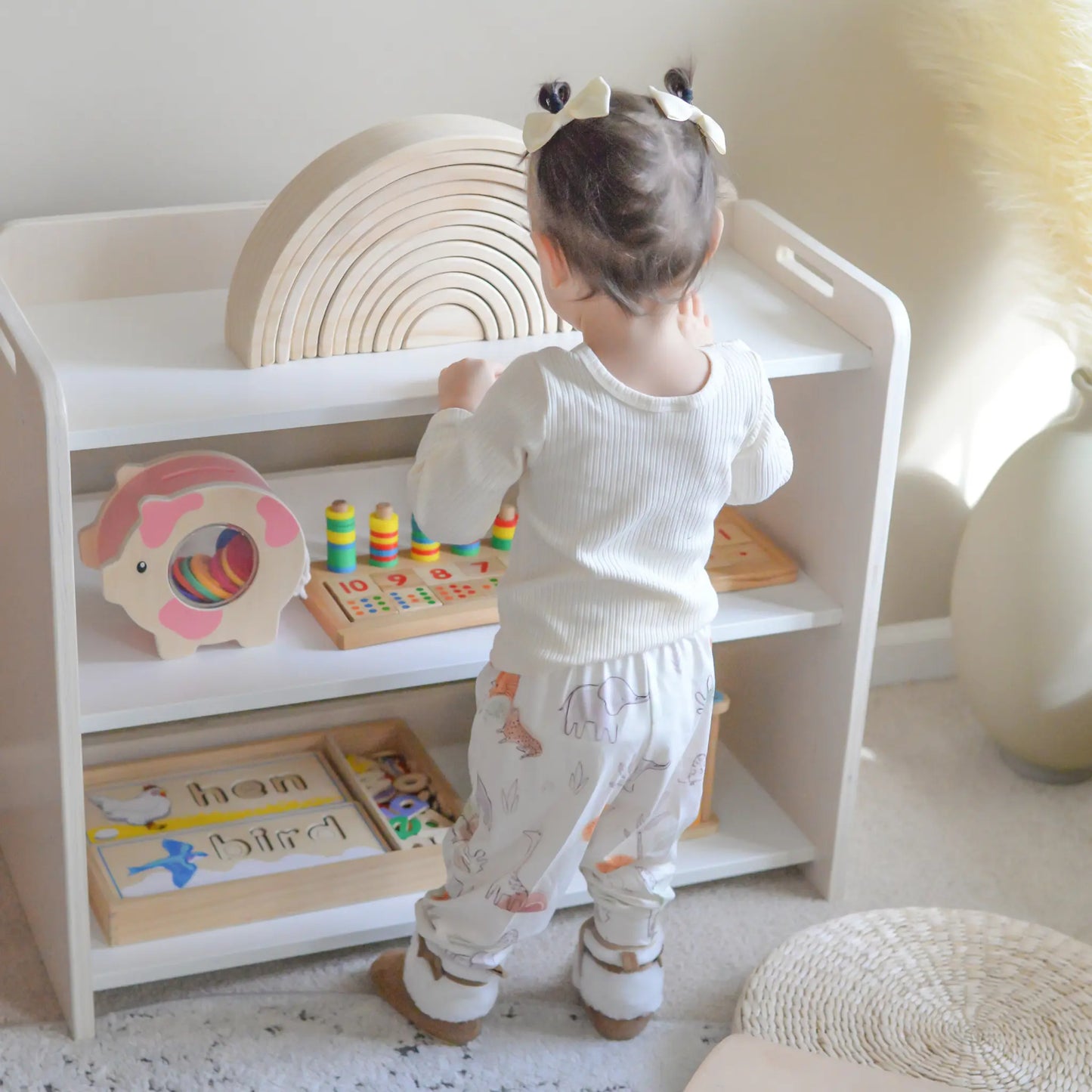 Premium Montessori shelf for toddlers, made in Canada from birch plywood with rounded corners. Features three accessible levels for toys and learning materials, including green storage bins on the bottom shelf designed to encourage independence and organization in young children.
