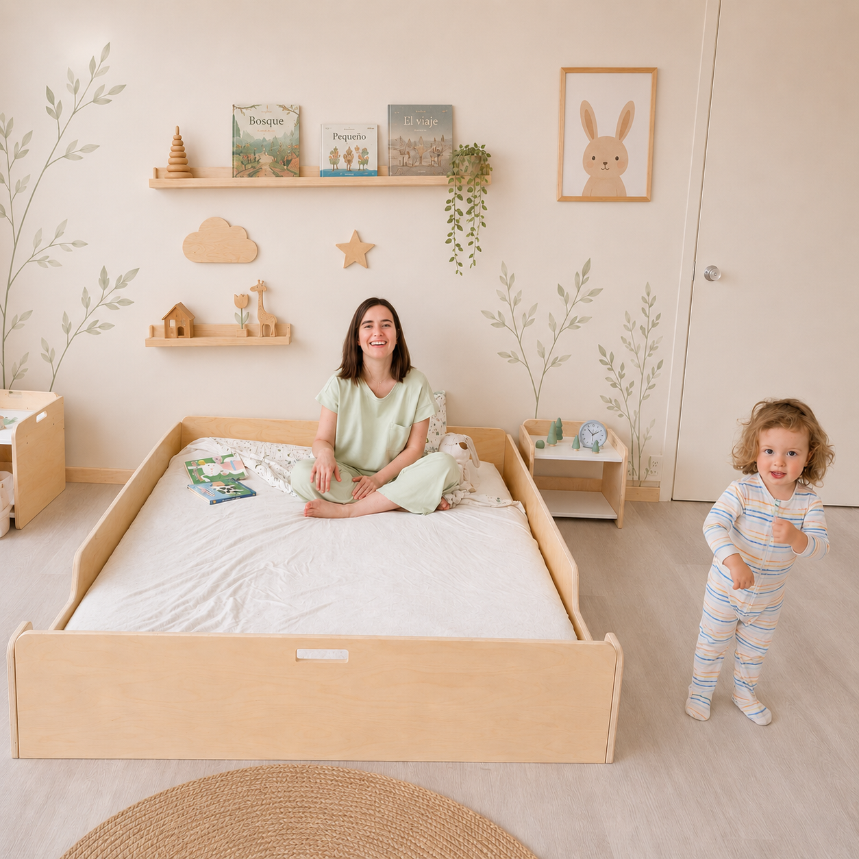 A woman and a child are sitting on a Montessori Floor bed from Sapiens Child in a child-friendly room with wooden furniture and decor.